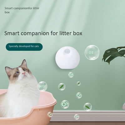 White spherical smart pet deodorizer with a sensor, designed for litter basins, shown against a light gray background with green leaves. - Image 5