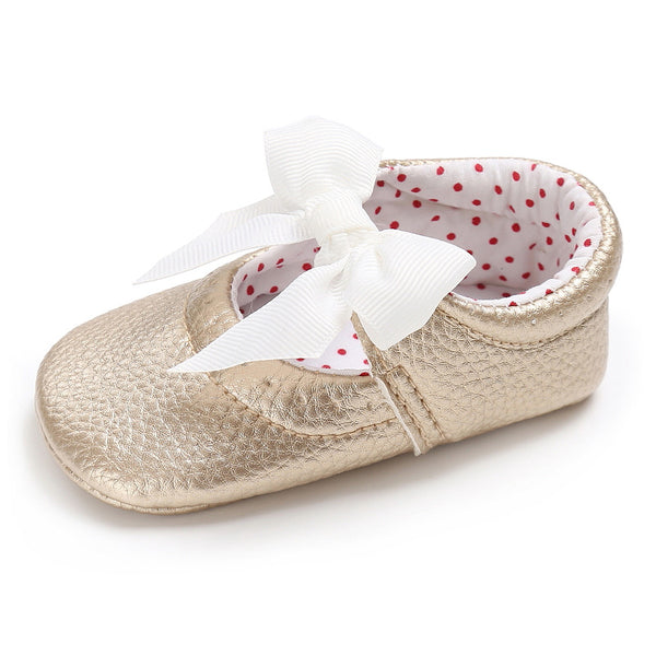 Pink baby soft sole princess shoes with a decorative bow and red polka dot lining, perfect for infants.