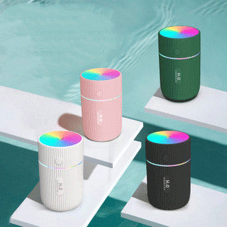 White portable ultrasonic humidifier with ribbed texture, colorful LED lights, and a power button.