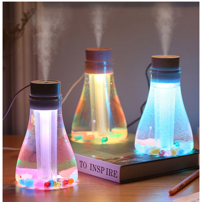 Wishing bottle humidifier with a clear body, white top, and colorful decorative stones at the bottom. - Image 5