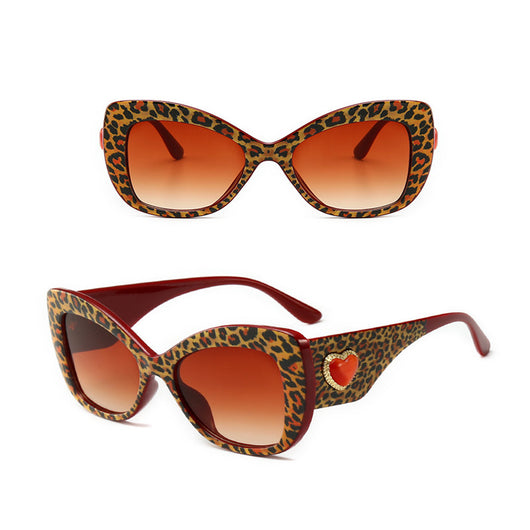 Leopard print cat-eye sunglasses with a red frame, gradient brown lenses, and a red heart embellishment. - Image 5