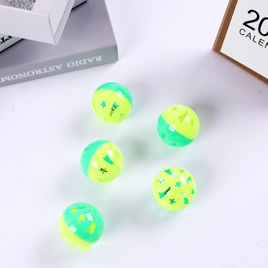 Five hollow green and yellow plastic cat toy balls with star-shaped cutouts scattered on a white surface. - Image 7