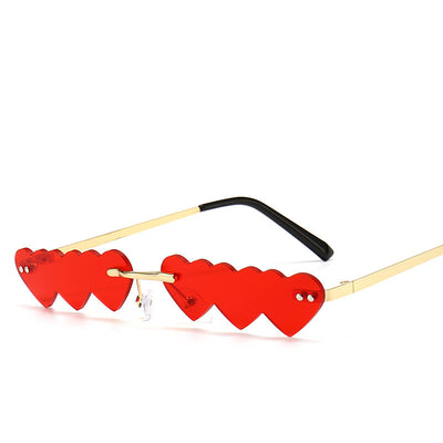 Women's rimless sunglasses with unique heart-shaped black lenses and gold-colored metal temples.
