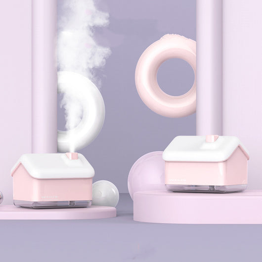 Pink and white house-shaped humidifier and essential oil diffuser with a clear base and a white power cord. - Image 4