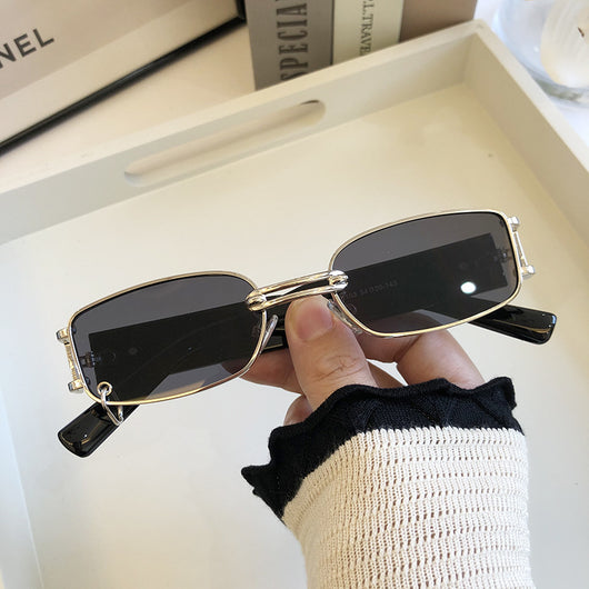 Black rectangular sunglasses with dark lenses and a thin metal frame, held by a hand against a light background. - Image 12