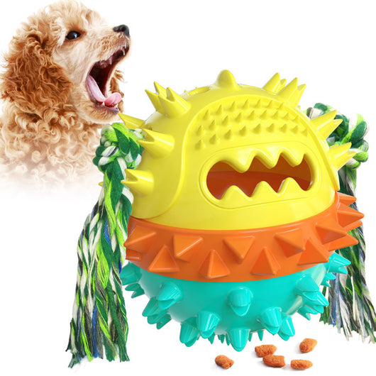 Yellow spiky dog toy with orange band and green rope, designed for chewing and treat dispensing, next to a yawning puppy. - Image 7