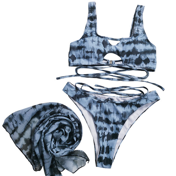 Blue and black tie-dye three-piece bikini set with cross-tie top, matching bottoms, and sheer sarong.