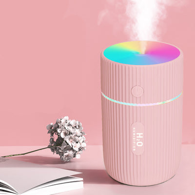 White cylindrical humidifier with ribbed texture, colorful LED lights, and a power button, ideal for home, office, or car.