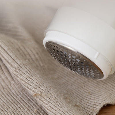 White wireless handheld electric iron and lint remover in use on a white shirt, with close-ups of its features. - Image 4