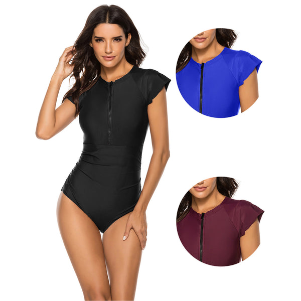 Black one-piece swimsuit with short sleeves and a front zipper, featuring ruched sides, modeled by a woman.