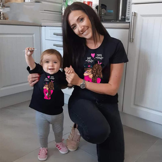 Mother and daughter wearing matching gray short-sleeved t-shirts with a cartoon graphic of a mother holding a child, both wearing Minnie Mouse ears, and text "B - Image 2