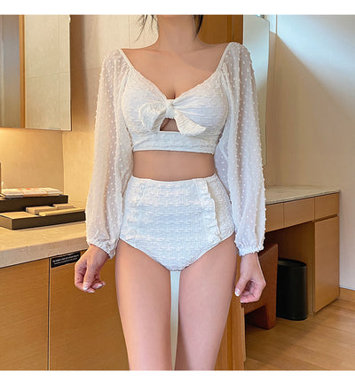 White long-sleeve bikini with a bow-front crop top and high-waisted bottoms with ruffled sides. - Image 11
