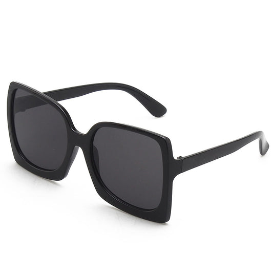Oversized square-frame sunglasses with translucent peach frames and brown gradient lenses on a white background.