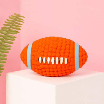 Orange textured latex dog toy shaped like an American football with blue and white accents, measuring 14cm long and 8cm wide.