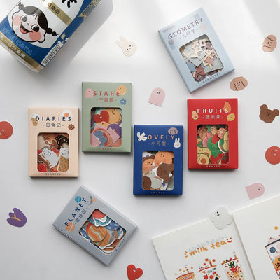 Six boxes of assorted stickers, including themes like geometry, fruits, planets, and cute characters, displayed on a white surface. - Image 21