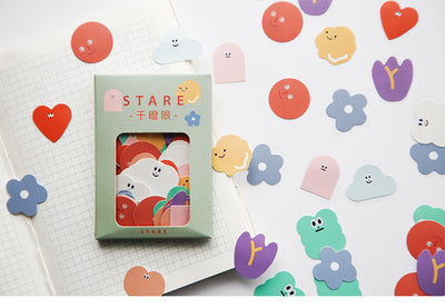 Six boxes of assorted stickers, including themes like geometry, fruits, planets, and cute characters, displayed on a white surface. - Image 3