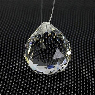 Clear faceted crystal ball bead, possibly K9 crystal, with a hole for stringing, against a dark background. - Image 9