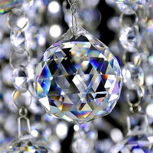 Clear faceted crystal ball bead, possibly K9 crystal, with a hole for stringing, against a dark background. - Image 3