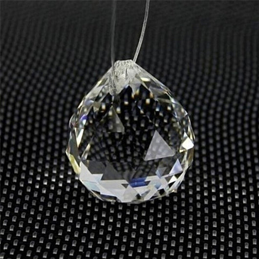 Clear faceted crystal ball bead, possibly K9 crystal, with a hole for stringing, against a dark background. - Image 6