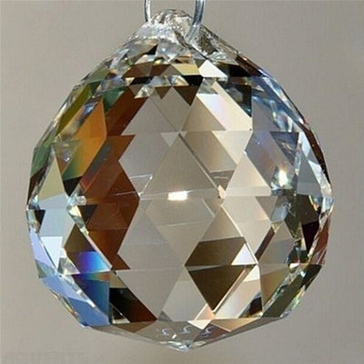 Clear faceted crystal ball bead, possibly K9 crystal, with a hole for stringing, against a dark background.