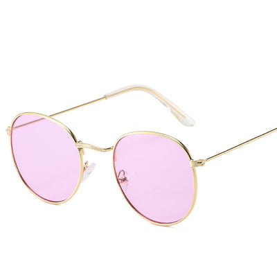 Retro oval sunglasses with pink lenses and a gold metal frame, featuring clear temple tips. - Image 17