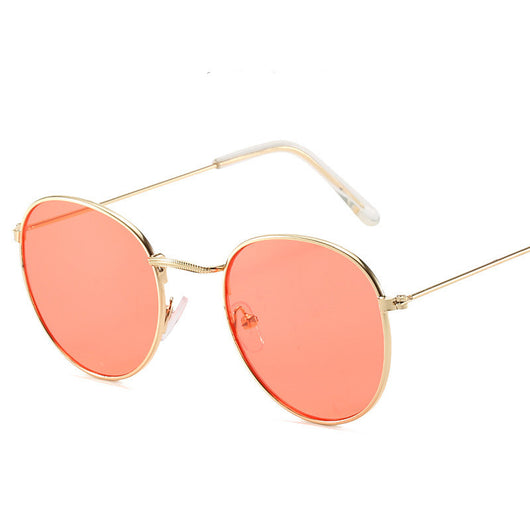 Retro oval sunglasses with pink lenses and a gold metal frame, featuring clear temple tips. - Image 4