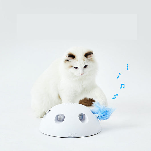White cat playing with a white dome-shaped electric cat toy, featuring blue feathers visible through openings. - Image 7
