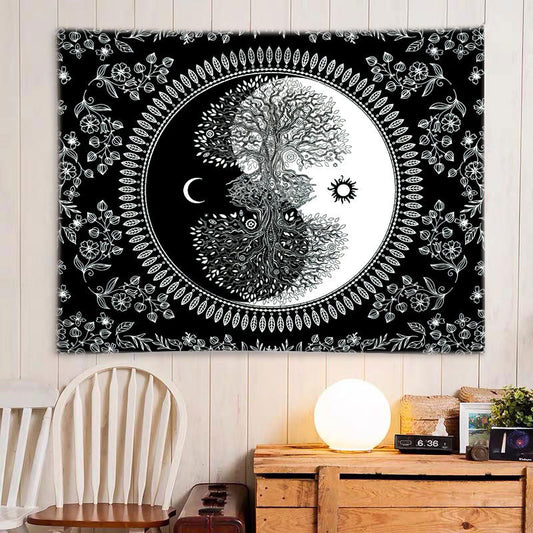 Black and white Tree of Life Yin Yang tapestry with floral border, hanging on a light wooden wall.