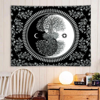 Black and white Tree of Life Yin Yang tapestry with floral border, hanging on a light wooden wall.