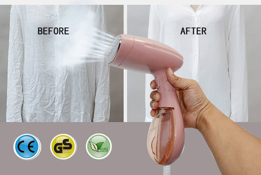 Pink handheld garment steamer with a clear water tank, silver soleplate, and a detachable brush attachment. - Image 2