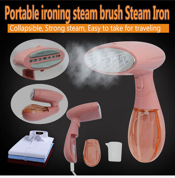 Pink handheld garment steamer with a clear water tank, silver soleplate, and a detachable brush attachment.