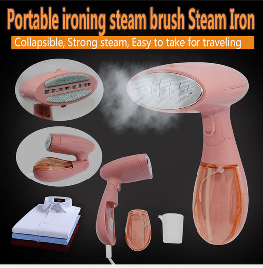 Pink handheld garment steamer with a clear water tank, silver soleplate, and a detachable brush attachment.