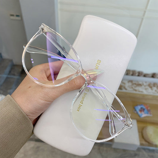 Transparent pink round-face anti-blue light glasses with clear lenses, held against a white glasses case. - Image 7