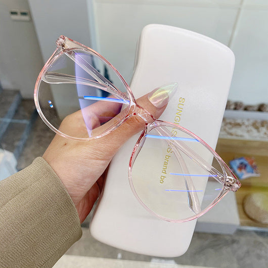Transparent pink round-face anti-blue light glasses with clear lenses, held against a white glasses case. - Image 9