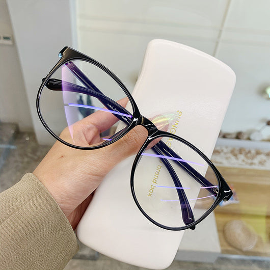 Transparent pink round-face anti-blue light glasses with clear lenses, held against a white glasses case. - Image 3