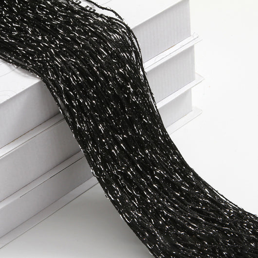Champagne string curtain with flashing silver metallic threads, draped over white boxes. - Image 26
