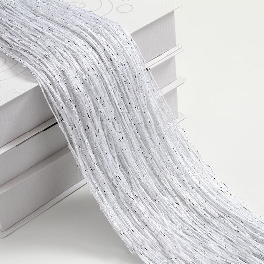 Champagne string curtain with flashing silver metallic threads, draped over white boxes. - Image 28