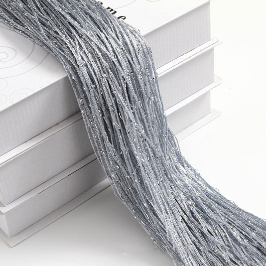 Champagne string curtain with flashing silver metallic threads, draped over white boxes. - Image 29