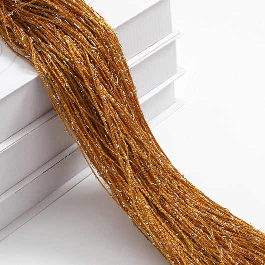 Champagne string curtain with flashing silver metallic threads, draped over white boxes. - Image 16