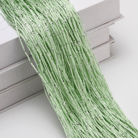 Champagne string curtain with flashing silver metallic threads, draped over white boxes. - Image 18