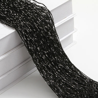 Champagne string curtain with flashing silver metallic threads, draped over white boxes. - Image 10