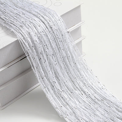 Champagne string curtain with flashing silver metallic threads, draped over white boxes. - Image 11