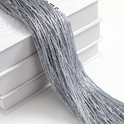 Champagne string curtain with flashing silver metallic threads, draped over white boxes. - Image 8