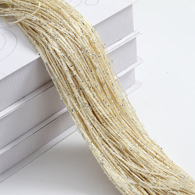 Champagne string curtain with flashing silver metallic threads, draped over white boxes. - Image 4