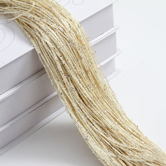 Champagne string curtain with flashing silver metallic threads, draped over white boxes. - Image 4