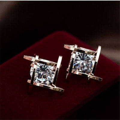 Gold-tone square stud earrings with clear zircon gemstones set in a hollow tic-tac-toe geometric frame. - Image 13
