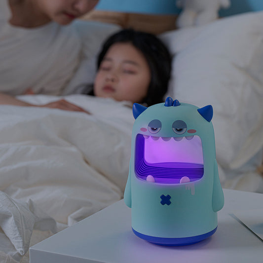 Pink monster-shaped mosquito killer lamp with a wide open mouth, horns, and a small red cross detail.