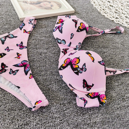 Pink butterfly print bikini with a push-up top and thong bottom, styled with pink sunglasses and a straw bag. - Image 12