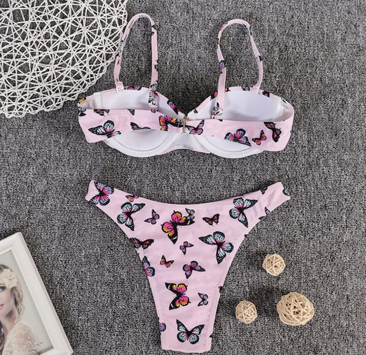 Pink butterfly print bikini with a push-up top and thong bottom, styled with pink sunglasses and a straw bag. - Image 4