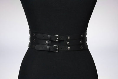 Women's black leather waist belt with three layers, silver-tone metal O-rings, and rivets on a black mannequin. - Image 8